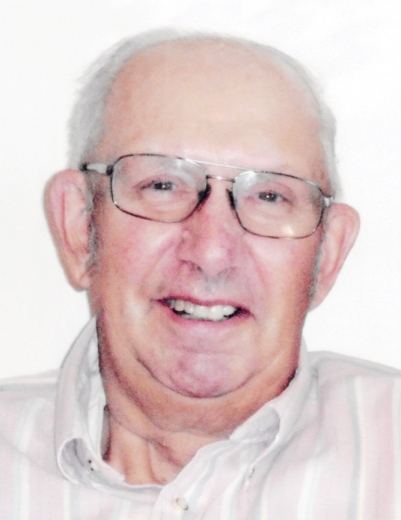 Larry smiles in a close-up photo. He wears large, wire-framed glasses and a button down shirt.