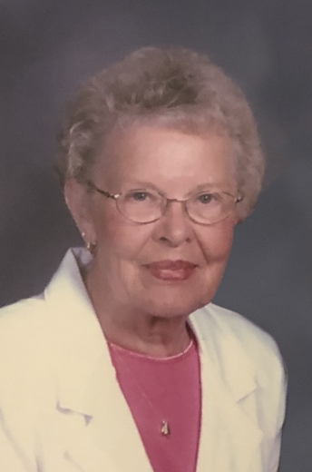 A profile photo of Janette, wearing a cream-colored blazer and a pink blouse.