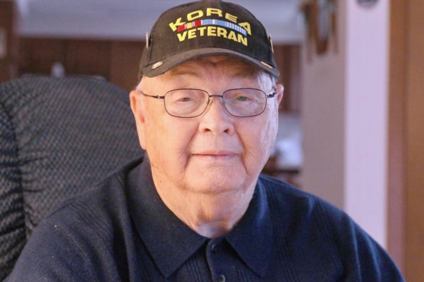 Marlyn has a content expression. He wears a Korea veteran hat and a dark polo.
