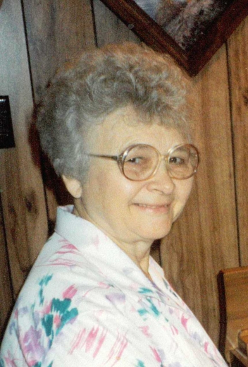 Arlene turns to look at the camera in this headshot. She is wearing a floral blouse.