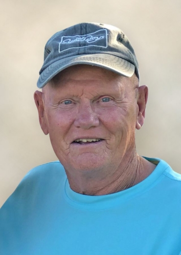 Bennett wears a cyan tshirt and Beach Boys ballcap.